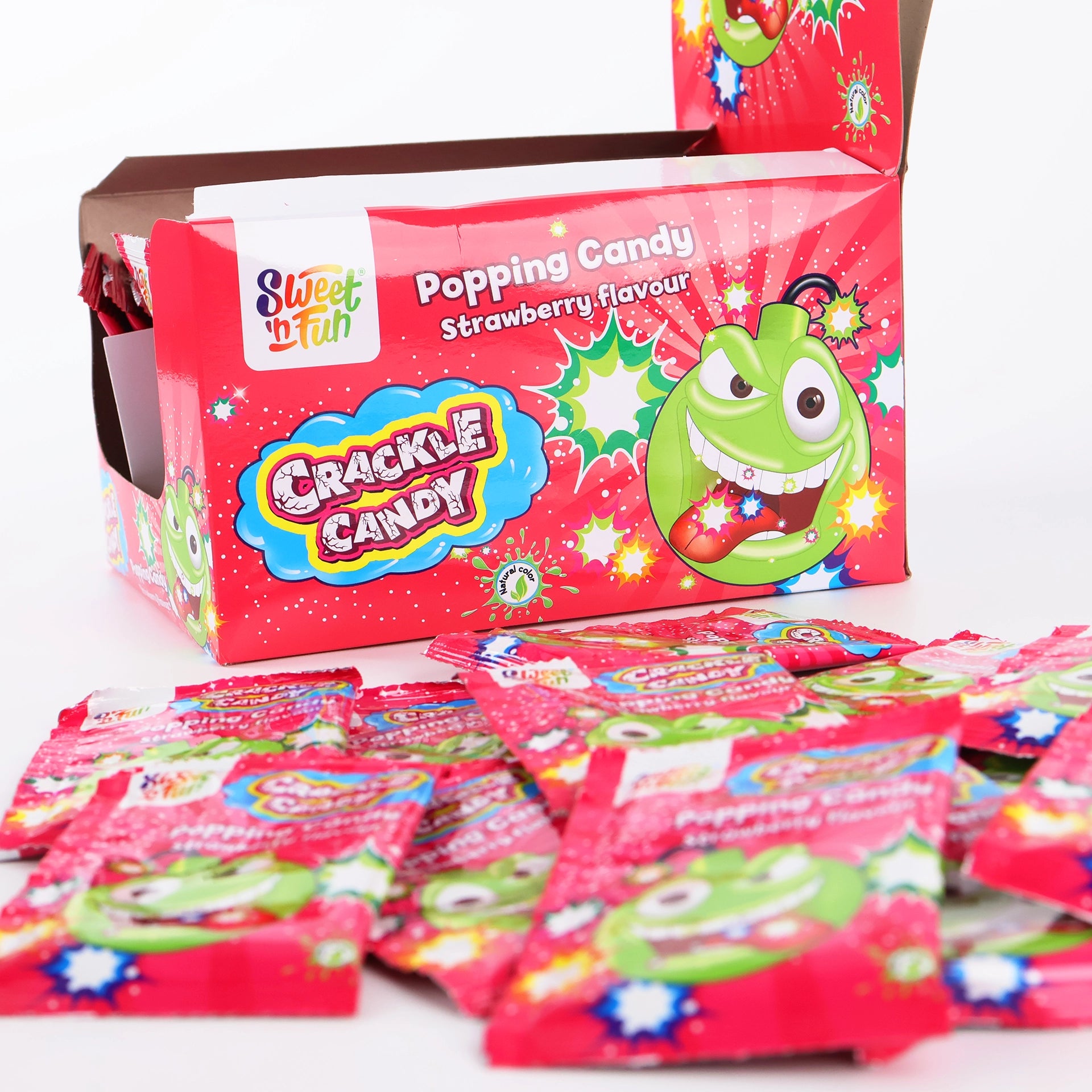 Plusieurs sachets de Crackle Candy Fraise disposés devant leur boîte présentoir ouverte.