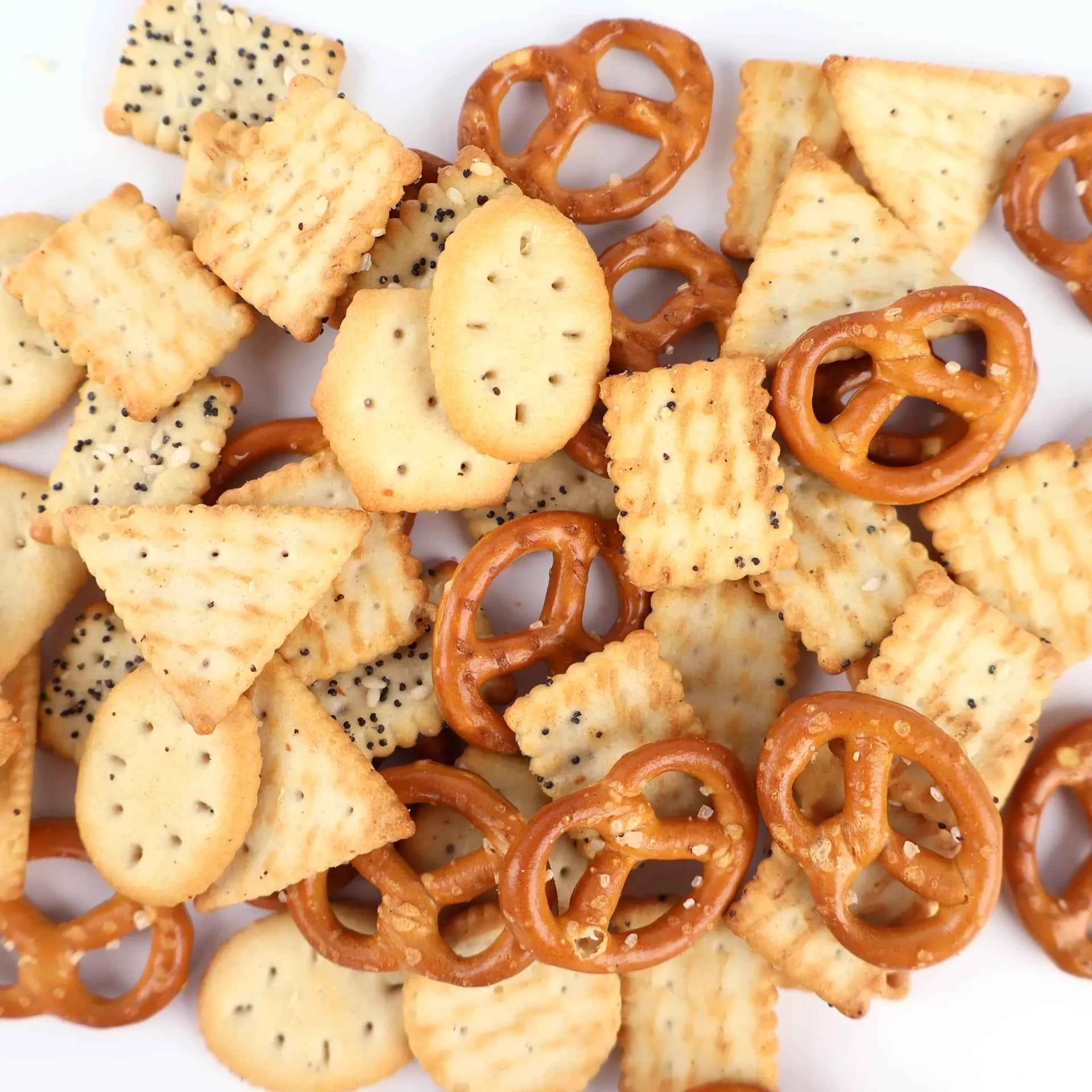 Gros plan sur la variété de biscuits apéritifs : bretzels croustillants et crackers de formes diverses.