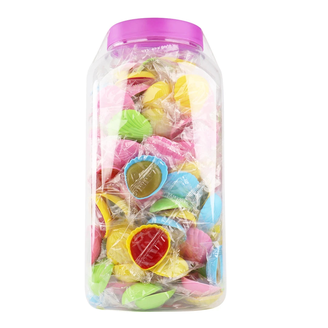 Vue rapprochée de la méga boîte montrant les coquillages multicolores (rose, jaune, vert, orange) emballés individuellement.