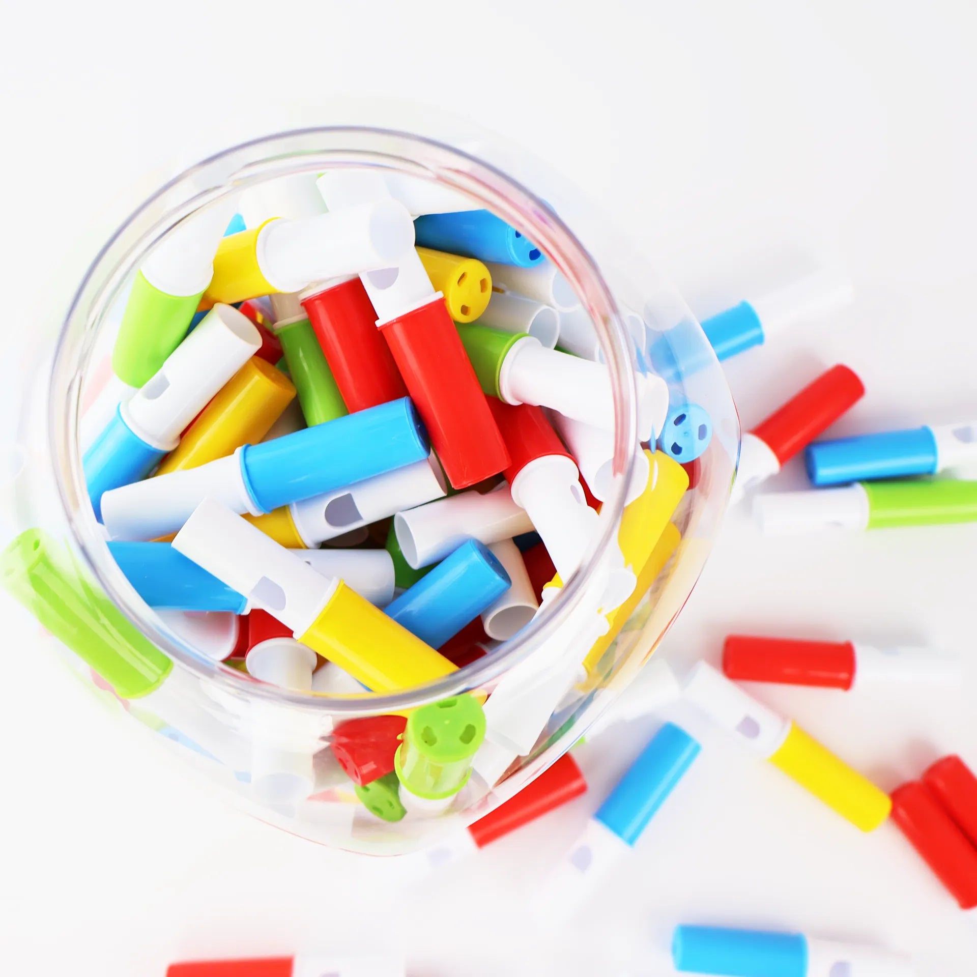 Sifflets en dextrose colorés vus de dessus à l'intérieur du pot ouvert.